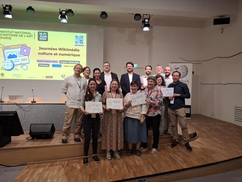 Groupe de personnes présentant les certificats de label décernés par Wikimédia